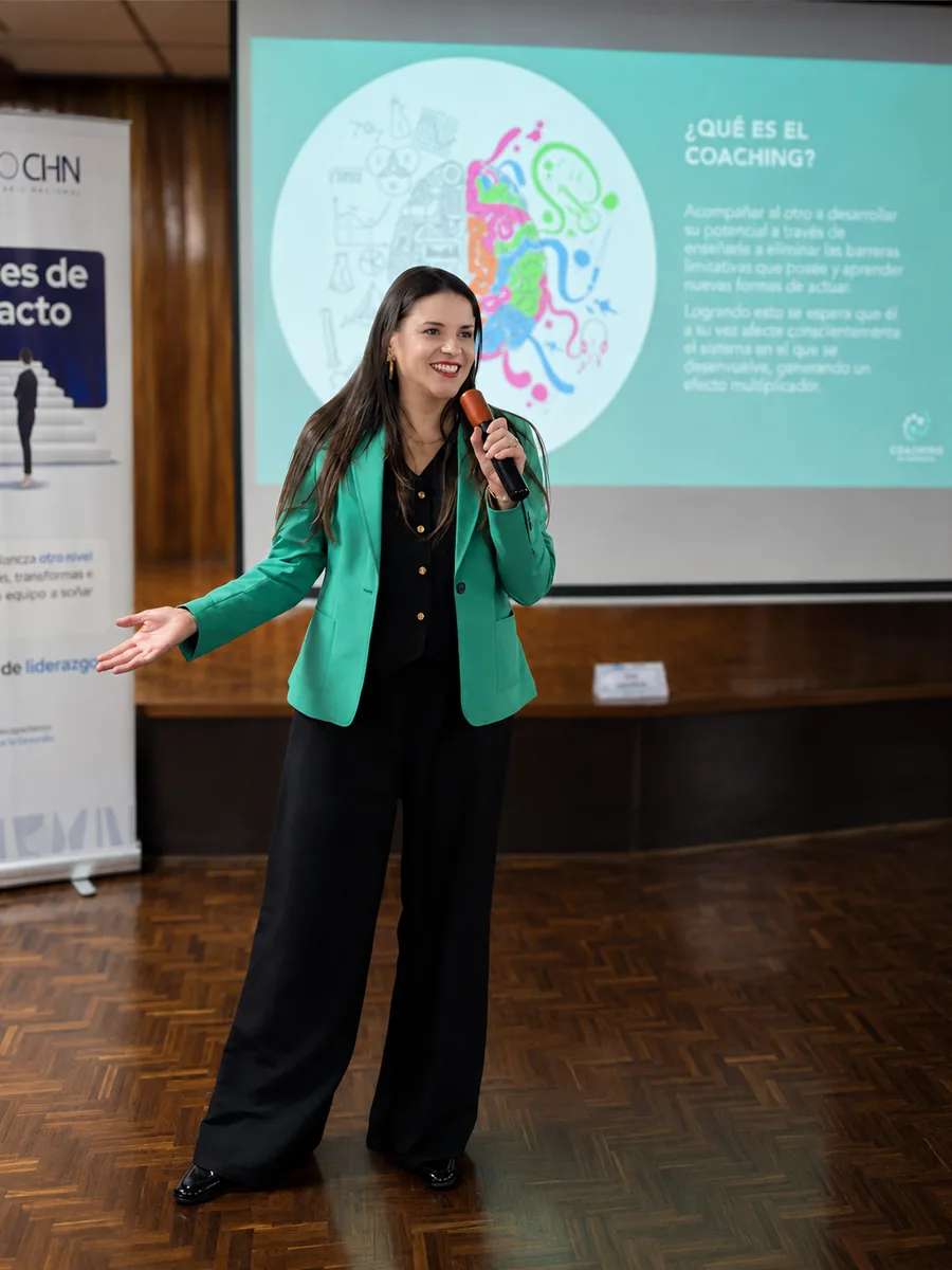 Facilitadora presentando frente a una pantalla de objetivos del programa